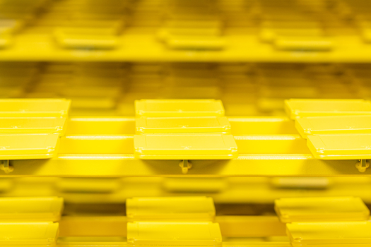 Gelb lackierte Metallbauteile auf einem Gestell.jpg